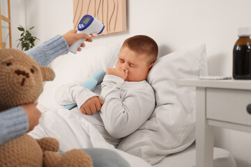 Mother taking care of her sick son in bed