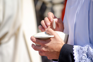 a priest holds the calix with the sacred form during the sacrament of communion at a catholic...