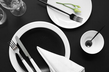 Table setting in white and black colors on dark background