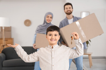 Cute Muslim boy with key and his parents in their new house