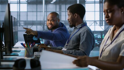 Data center engineers maintaining company network infrastructure by installing, configuring,...