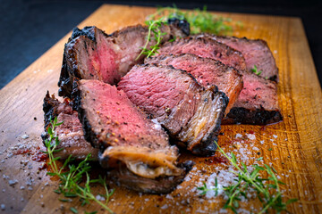 Traditional grilled barbecue dry aged tomahawk beef steak meat with salt and fresh herbs served and...