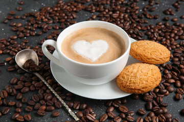 Cup of hot coffee with sweet cookies and beans on black background