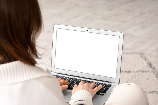 Young woman using blank laptop at home, closeup