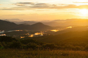 Golden Sunset Over Rolling Green Hills and Misty Valleys in Nature