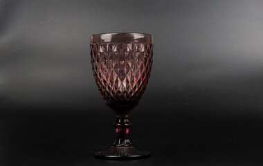 Wine glass made of colored glass. On a black background