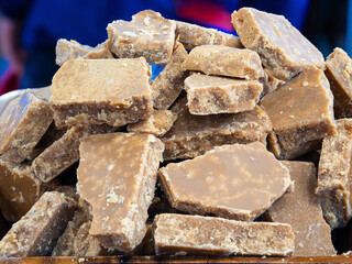 A pile of brown fudge pieces stacked together. Caramel-like color, showcasing its sweet, homemade appearance.