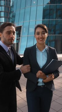 4K. POV. Young attractive Businessman in formal suit recommed his partner sexy pretty brownhair beautiful lady collegue with textpad to You. She strart to make offer. Glass building businesscentre bg