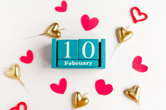 February 10. Blue cube calendar with month and date and decorative hearts on white background.