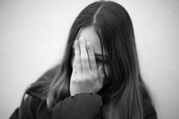 Fototapeta premium Teenage girl covers her face with her hands