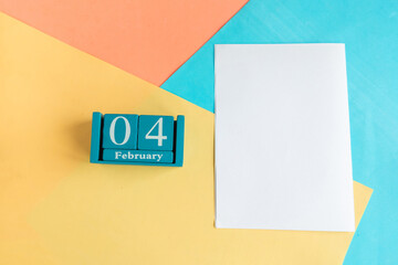 February 4. Blue cube calendar with month and date and white mockup blank on color geometric...