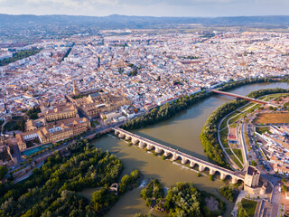 Fototapeta premium Aerial view of Historic centre of Cordoba with antique Roman Bridge over Guadalquivir river and medieval Mosque-Cathedral, Spain