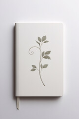 Minimalist white notebook with delicate watercolor botanical illustrations on the cover placed on white surface