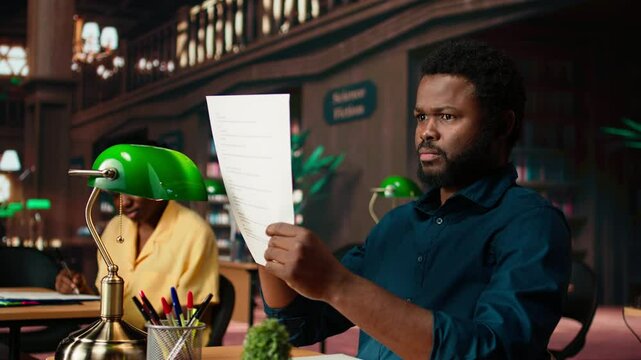 Black student rehearsing lines from the script for drama school course, auditioning for a theatre play competition. Young scholar reciting dialogue at the campus library. Camera A.