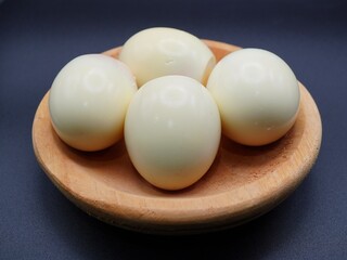 A perfectly boiled egg is placed against a striking black background, highlighting its simplicity and elegance