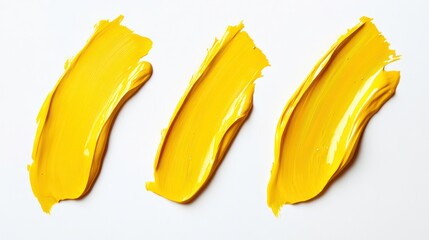 Three strokes of yellow glossy oil paint on white background