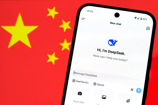 DeepSeek AI app chat seen on the smartphone and blurred Chinese flag on the background. Concept for a new chinese AI rival to ChatGPT. Stafford, United Kingdom, January 26, 2025