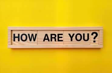 Fototapeta premium Wooden blocks arranged in frame ask How Question. Bright yellow background. Positive concept. Greeting image for social media, cards website. Simple, friendly. Perfect for motivational messages,