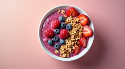 Bowl of fruit and granola on a pink surface