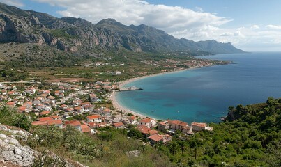 Fototapeta premium Coastal town nestled beneath mountains, serene bay view, ideal for travel or tourism promotion