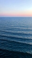 Fototapeta premium Serene ocean view with gentle waves and pastel horizon at dusk perfect for mobile wallpaper. Generative AI