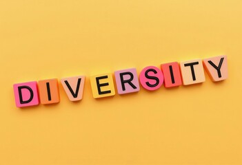 Colorful letter blocks spelling 'DIVERSITY' on a vibrant yellow background, highlighting the concept of inclusion and variety.