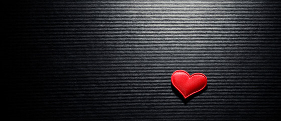 Single red heart illuminated on black background. Heart shape for a romantic theme celebrating...