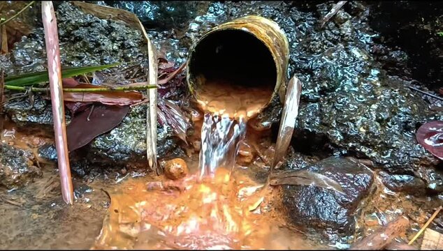 Water flows from the paralon, between natural and fresh river rocks