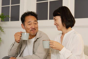 夜のリビングで会話する熟年夫婦