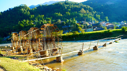 Wood water wheel Baler Machine in Agriculture Farm impeller lifted pumping water in river. Wooden Water Baler Machine green garden Farm blades by windy natural. Sustainable Resources Environment © aFotostock