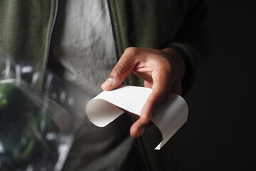 Close-Up of Hands Holding Receipt and Grocery Packet