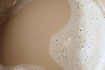 Creamy cappuccino foam in a close-up view at a cozy cafe in the afternoon