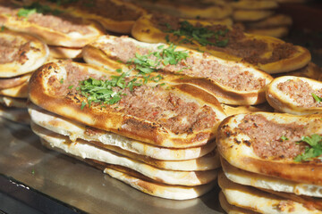 Delicious flatbreads topped with seasoned minced meat and fresh herbs at a street food vendor