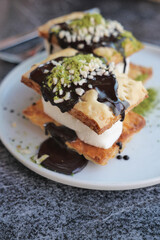 Delicious dessert stack featuring layers of pastry, cream, and chocolate sauce