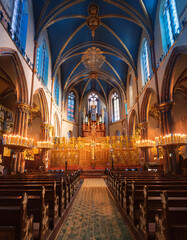 Fototapeta premium A grand church interior with a high vaulted ceiling, ornate altar, and rows of pews