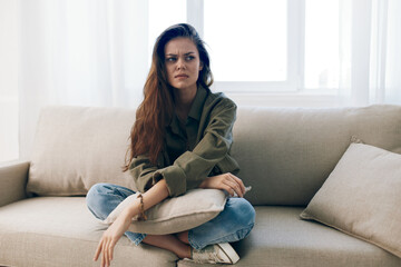 Obraz premium Overwhelmed Woman on Couch, Feeling Sad and Worried, Experiencing Mental Health Pain at Home