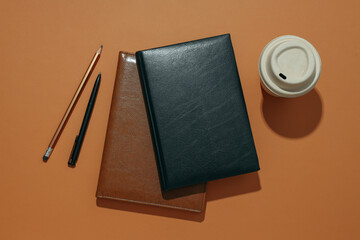 Black and brown notebooks with a cup of coffee