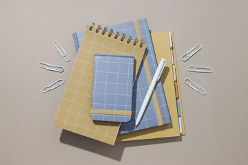Various notebooks with a pen and paper clips