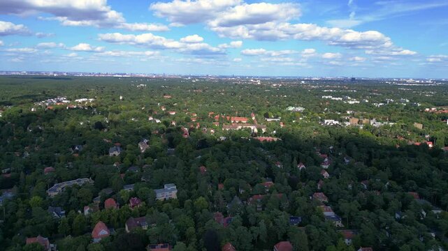nikolassee, a residential district in berlin, featuring houses nestled within a dense forest, with the city skyline visible on the horizon. Gorgeous aerial view flight panorama overview drone
