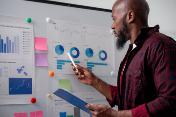 Businessman analyzing financial data, using charts and reports to make strategic decisions for...
