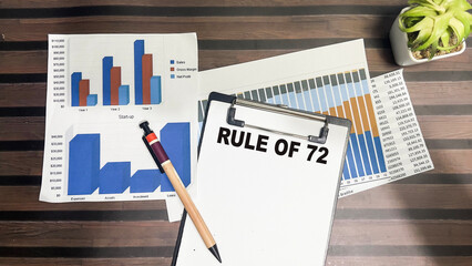 Concept of Rule of 72 write on paperwork isolated on Wooden Table.