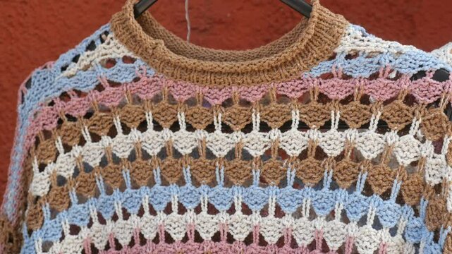 Colorful crochet sweater display in a local artisan market