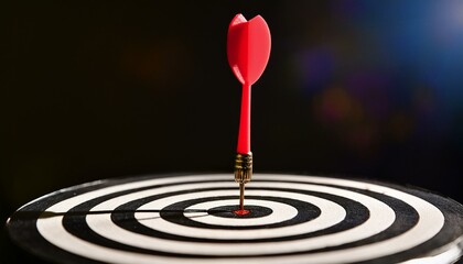 Fototapeta premium Red dart hitting the bullseye on a dartboard.