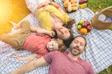 Top view of happy family spending time on holiday. mother, father and little son having picnic in...
