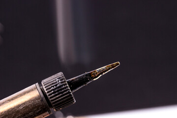 Naklejka premium soldering iron tip in working with smoke