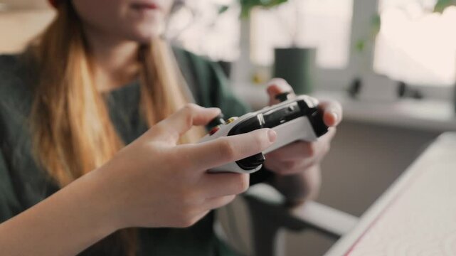 Close-up of gamer girl hands holding gamepad, pressing buttons with precision during an intense gaming session. Using advanced technology, she plays with focus and action, showcasing gaming skills