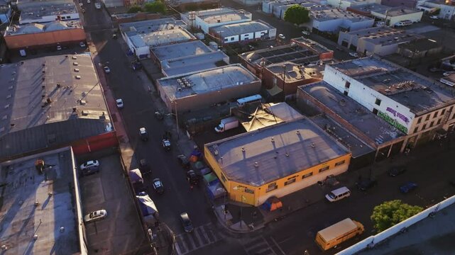 Aerial footage of the industrial Skid Row neighborhood in Los Angeles city at sunset, USA