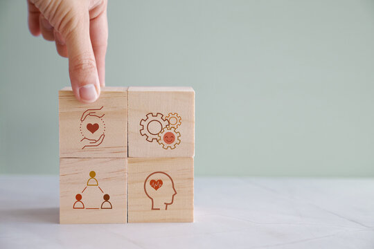 Hands holding wooden cube blocks with wellness icons, positive mental health, life balance concept

