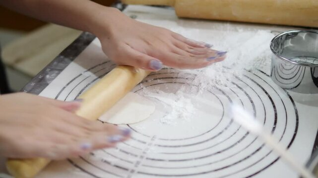 Hands rolling out gyoza dough on a floured surface with precision, showcasing the process of crafting Japanese dumpling wrappers, with kitchen tools like a rolling pin and sifter in the background