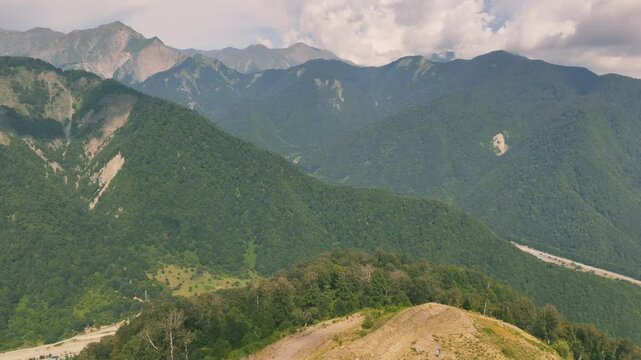 Drone view of lush green mountains with forest and unpaved roads on hill in Gebele, Azerbaijan